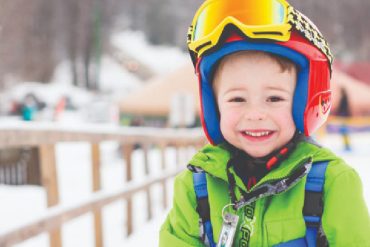 boy in winter attire on ski hill
