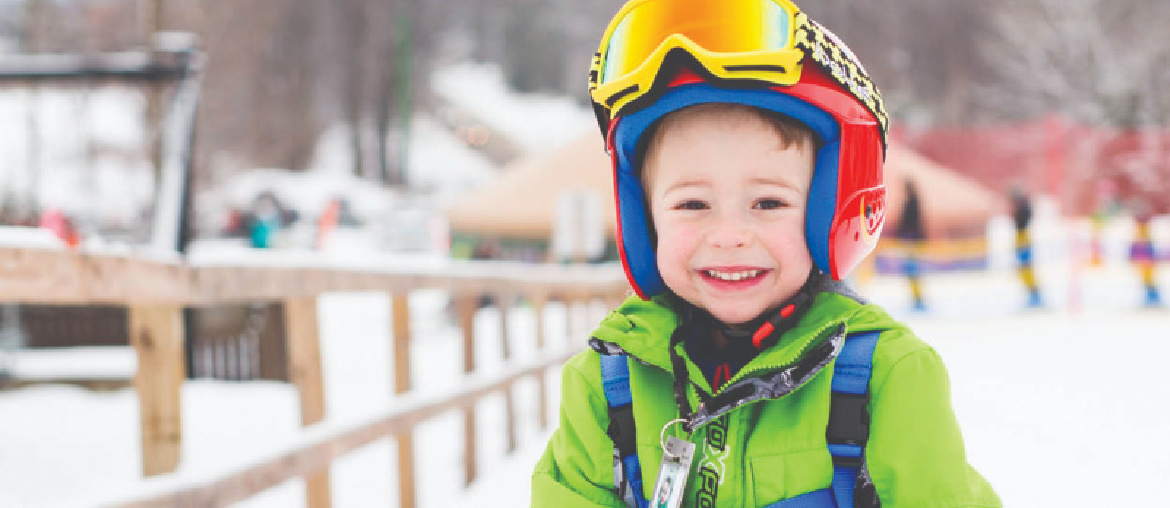 boy in winter attire on ski hill